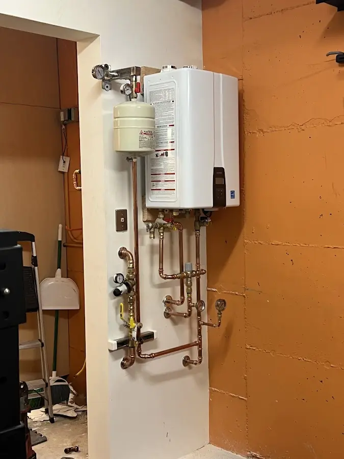 Plumbing technician inspecting water heater connections in Solebury